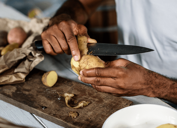 Close up of a man peeling potatoes